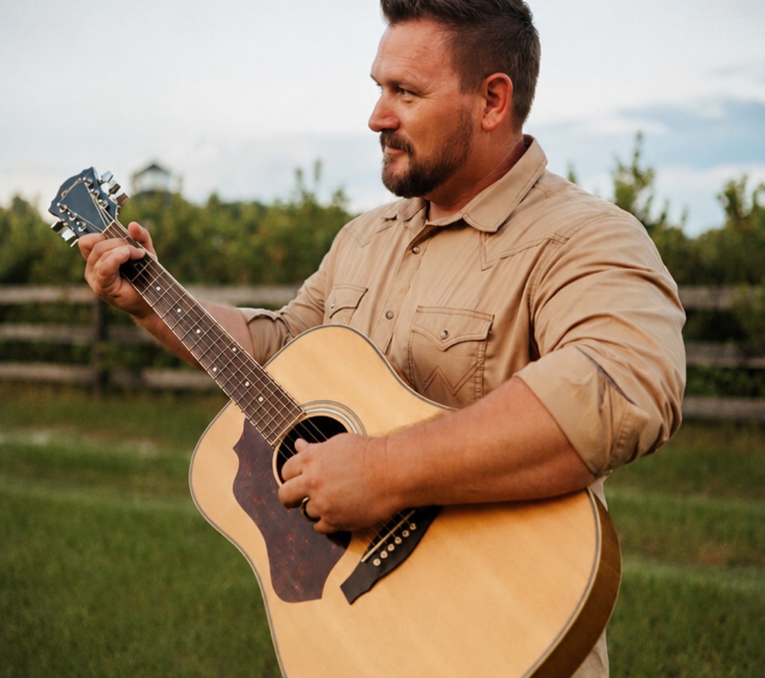 Nick Partin outdoors with his acoustic guitar